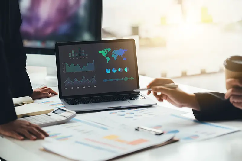 Businessman and woman discussing on stockmarket charts in office