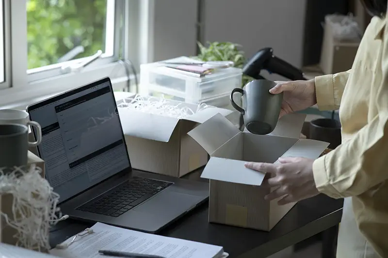 Closeup view of female online store small business owner seller entrepreneur packing package post shipping box preparing delivery parcel on table.