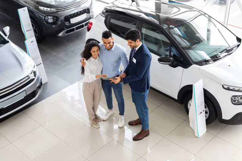 Top view of middle-eastern couple having conversation with sales assistant