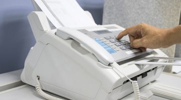 hand man are using a fax machine in the office, equipment for data transmission.