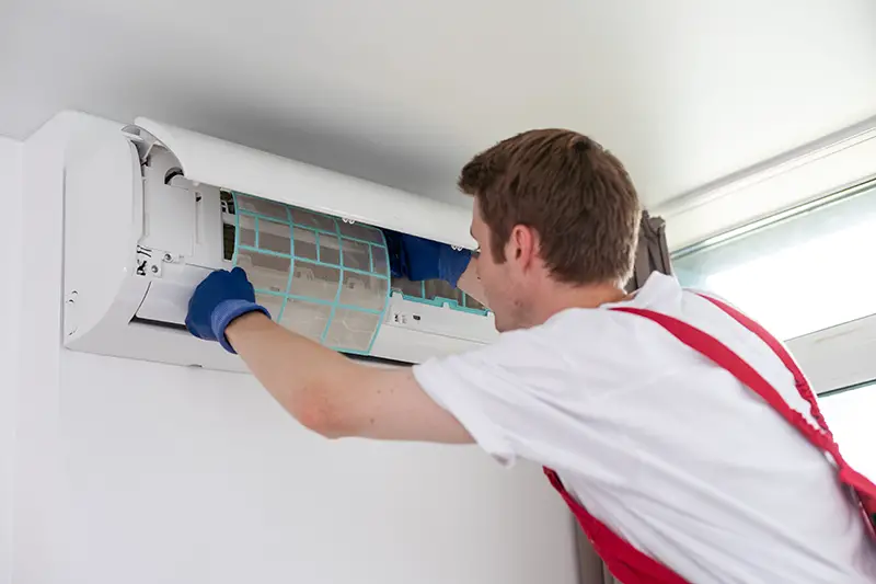 technician service removing air filter of the air conditioner for cleaning.
