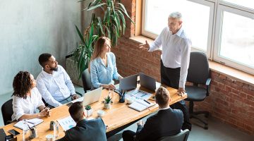 Employer Giving Speech On Meeting With Employees Sitting In Office