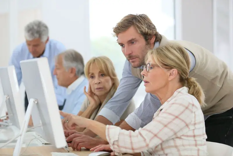 Instructor helping senior woman