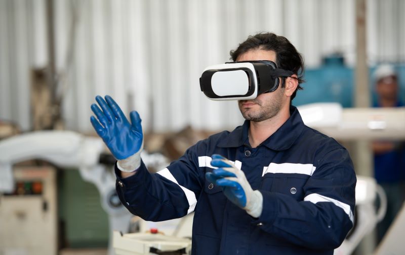 A young male engineer uses a VR machine