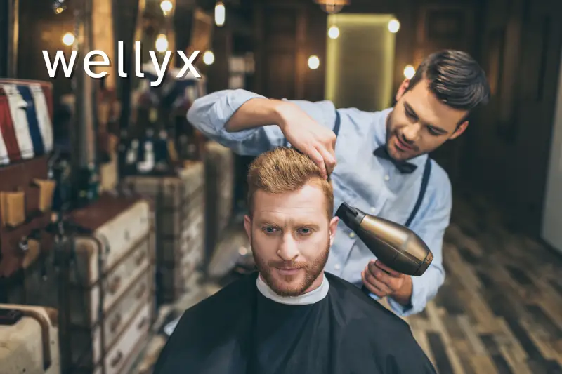 Barber drying hair of customer