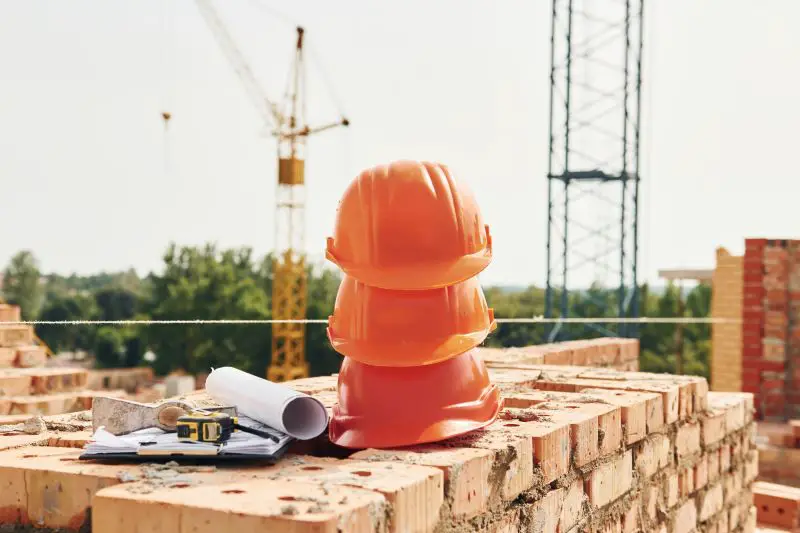 Close up view of protective hard hats that laying down on the bricks