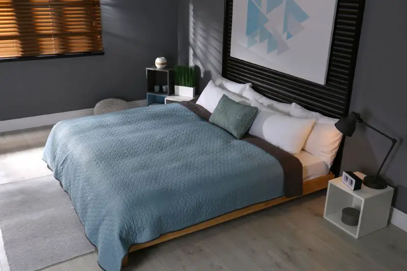 Comfortable bedroom with picture on decorative wall.