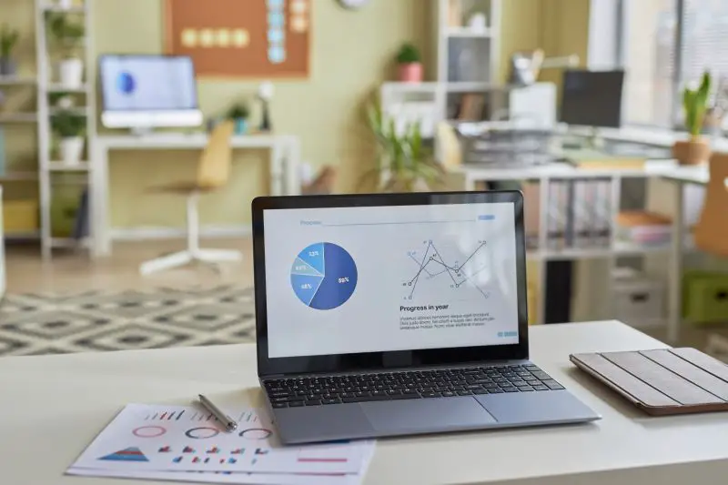 Open laptop computer with statistics data graphs on screen