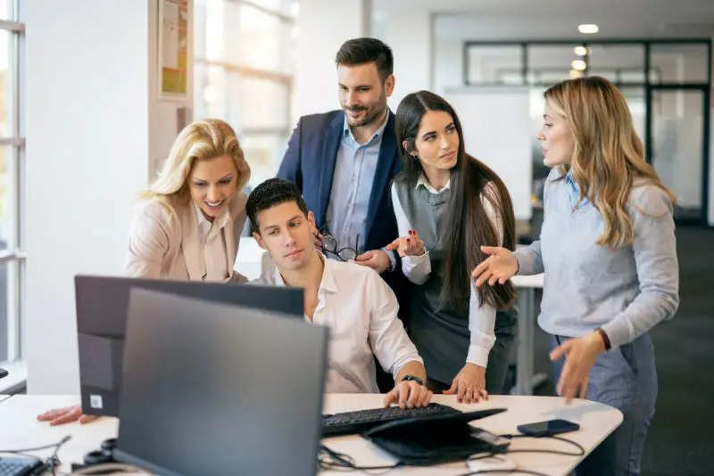 Group of business people gathered together at a table working on a project