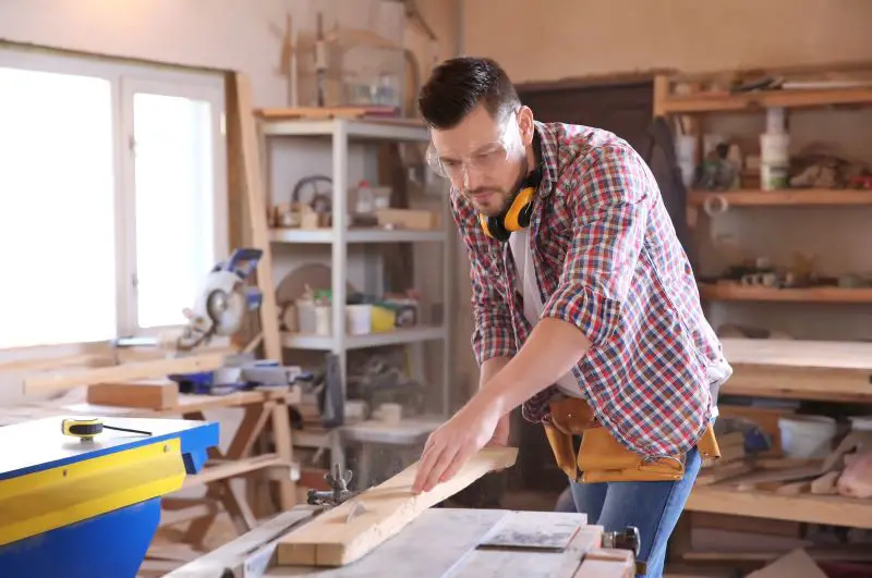 Carpenter sawing timber