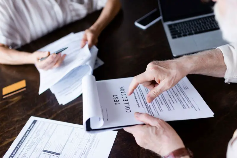 Cropped view of senior man pointing at paper with debt collection