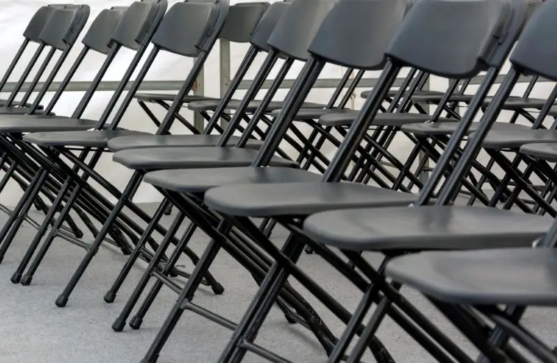 Numerous folding chairs arranged in a row