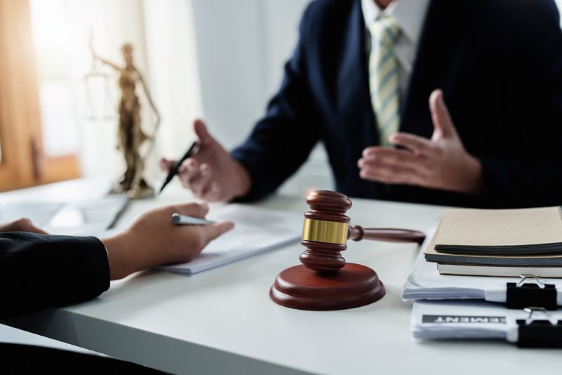 Focus at gavel, Attorney or Lawyer holding a pen is consulting with a client