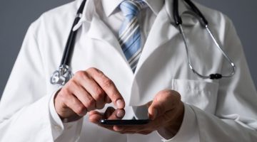 Close-up Of A Doctor's Hand Using Smartphone In Clinic
