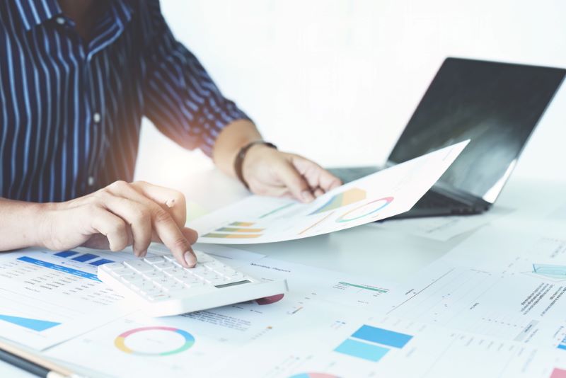 Businessman using a calculator to check company finances and cash flow