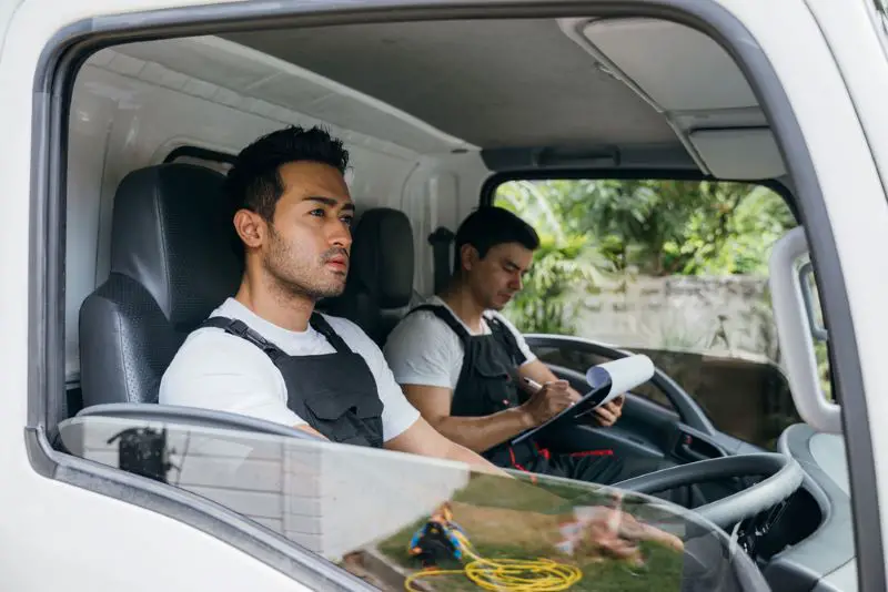 Mover workers transporting items in a commercial vehicle