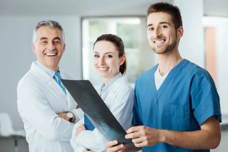 Medical team posing and examining an x-ray image
