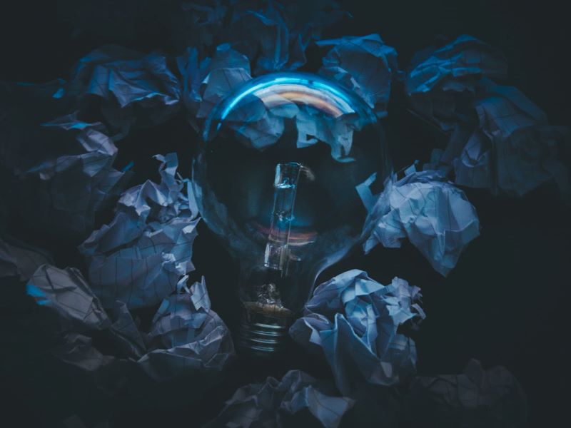 Light bulb surrounded by crumpled paper - depicting ideas