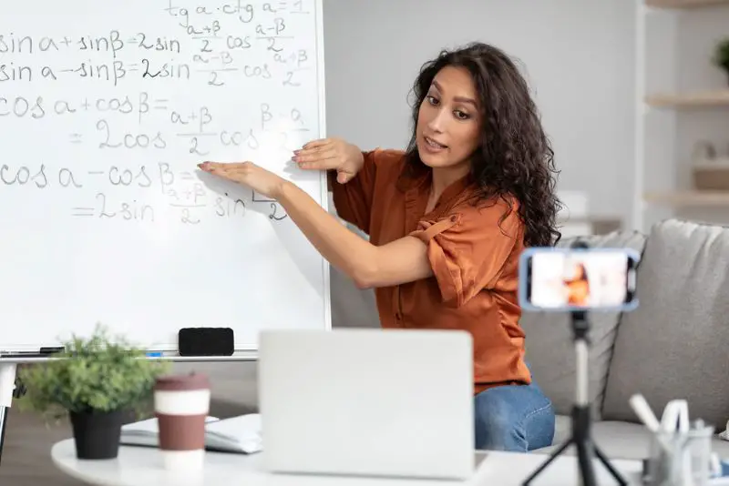 Math teacher showing board, giving virtual lecture to students