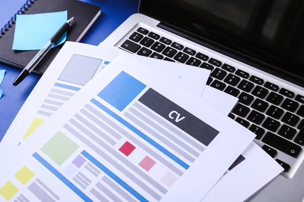 Job, interview. CV on the table across a laptop keyboard