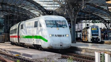 White train with red and green stripes on rail tracks