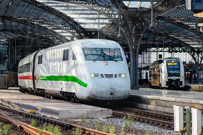 White train with red and green stripes on rail tracks