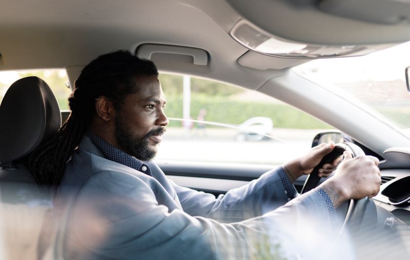 Hispanic Latino businessman driving a car