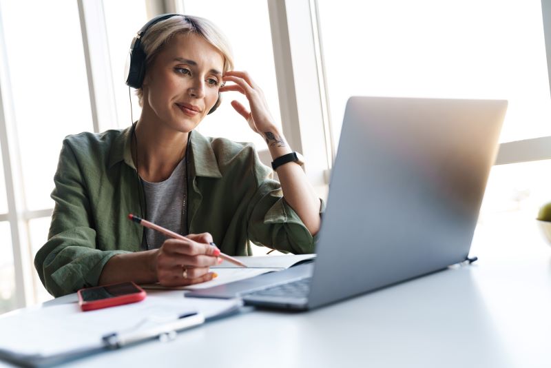 Middle aged blonde woman with short hair studying