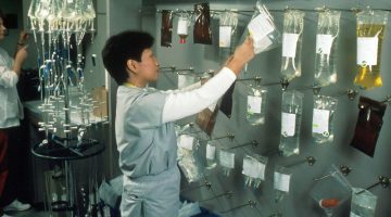 Asian female nurse hanging bags of chemotherapy drugs