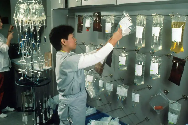 Asian female nurse hanging bags of chemotherapy drugs