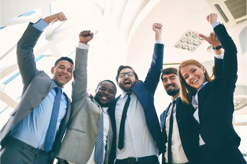 Diverse business team celebrating success after winning small business awards to boost credibility.