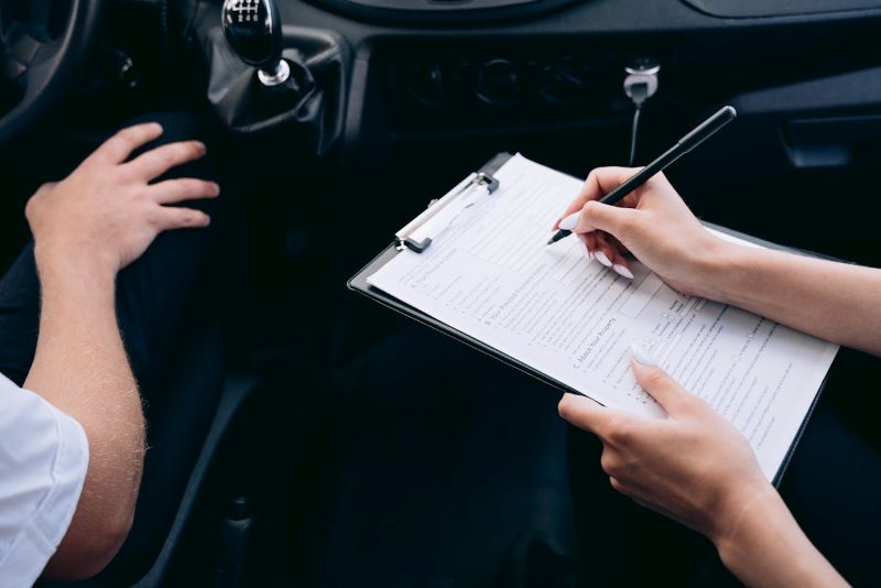 Person Writing on a Clipboard Inside a Vehicle