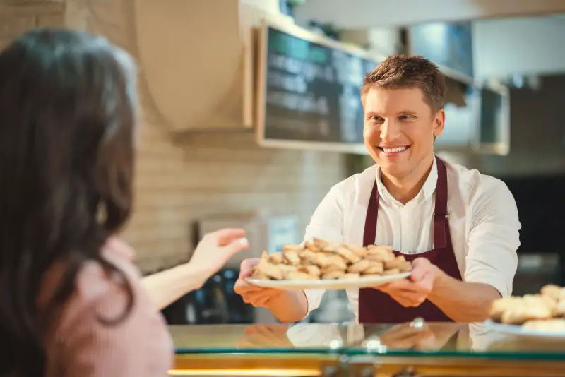 Happy baker serving the customer