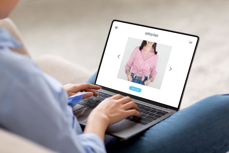 Person shopping for clothes online using a laptop.