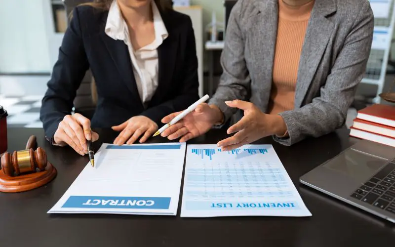 Female legal counsel reviewing paperwork business compliance at a desk in an office.