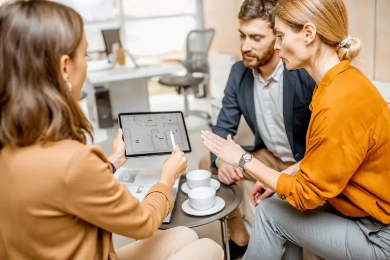 A young couple explores housing options at a real estate agency