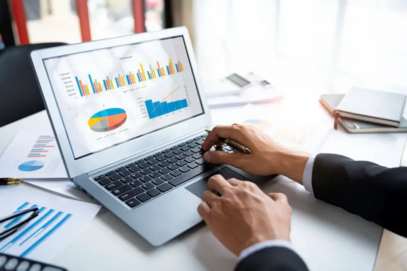 Business professional analyzing marketing performance charts on a laptop using profit tracking software