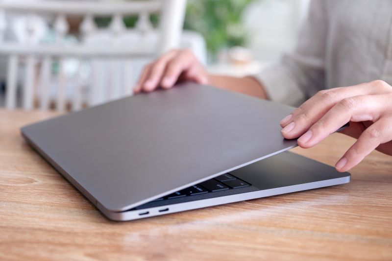 Closeup image of hands close and open a laptop computer on table