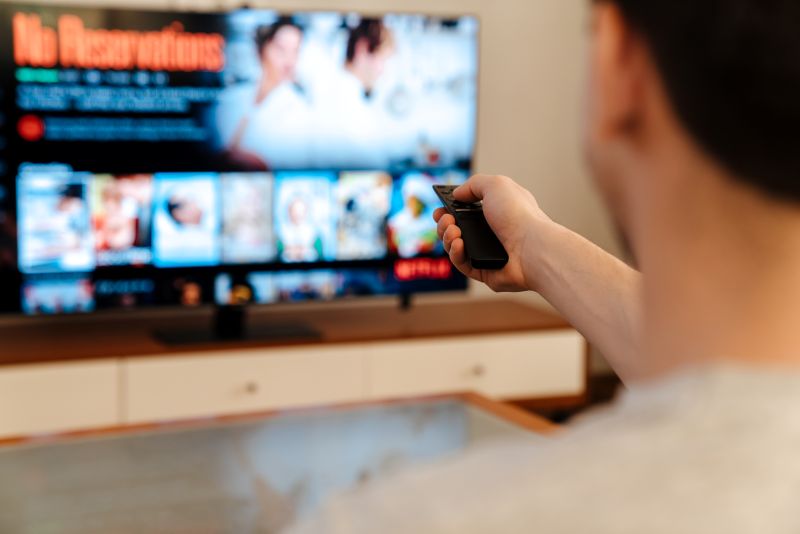 Person using a remote to stream content on a smart TV