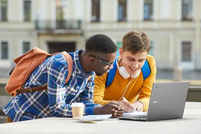 Two students studying together outside with an Acer Chromebook.