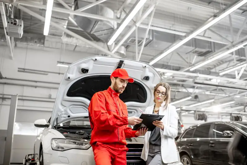 Woman client with auto mechanic at the car service