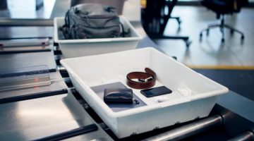 Personal Items, liquids and laptop in container at airport security check before flight.