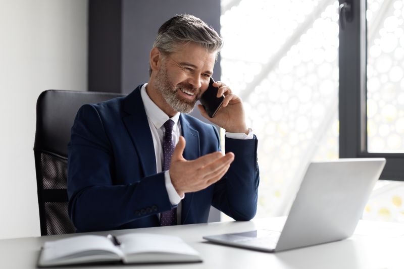 Corporate Communication. Handsome Middle Eaged Businessman Talking On Cellphone In Office