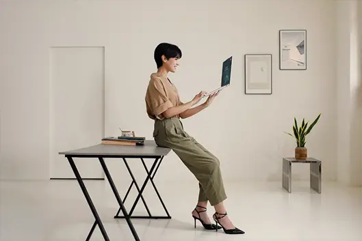 Woman using laptop while sitting at the desk.