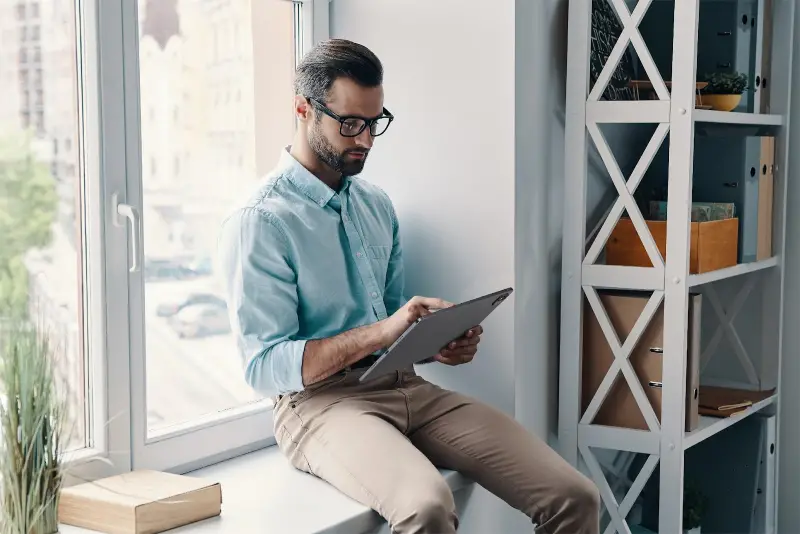 Businessman using laptop while sitting near the window