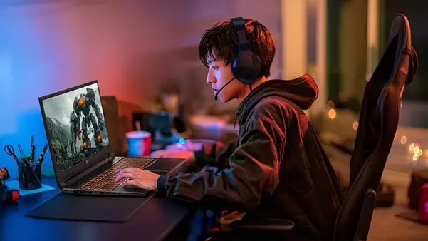 A young Asian boy playing an online game on a laptop
