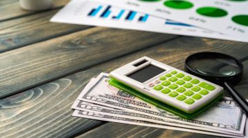Business graphs paper and calculator on table