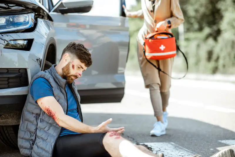 Woman driver with injured man on the road