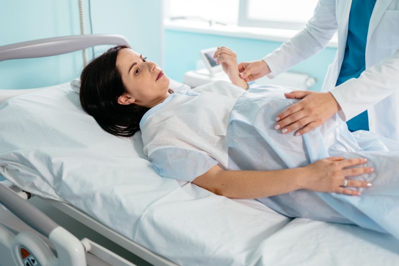 Doctor checking heart rate of pregnant woman before labour
