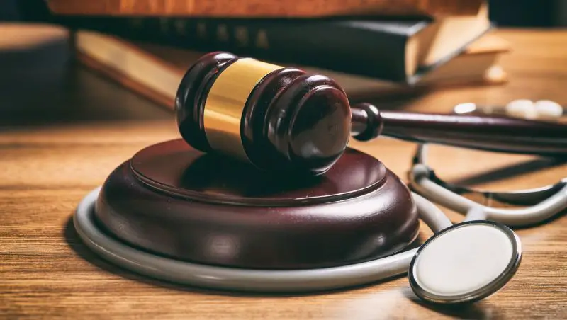Judge gavel and a stethoscope on a wooden desk